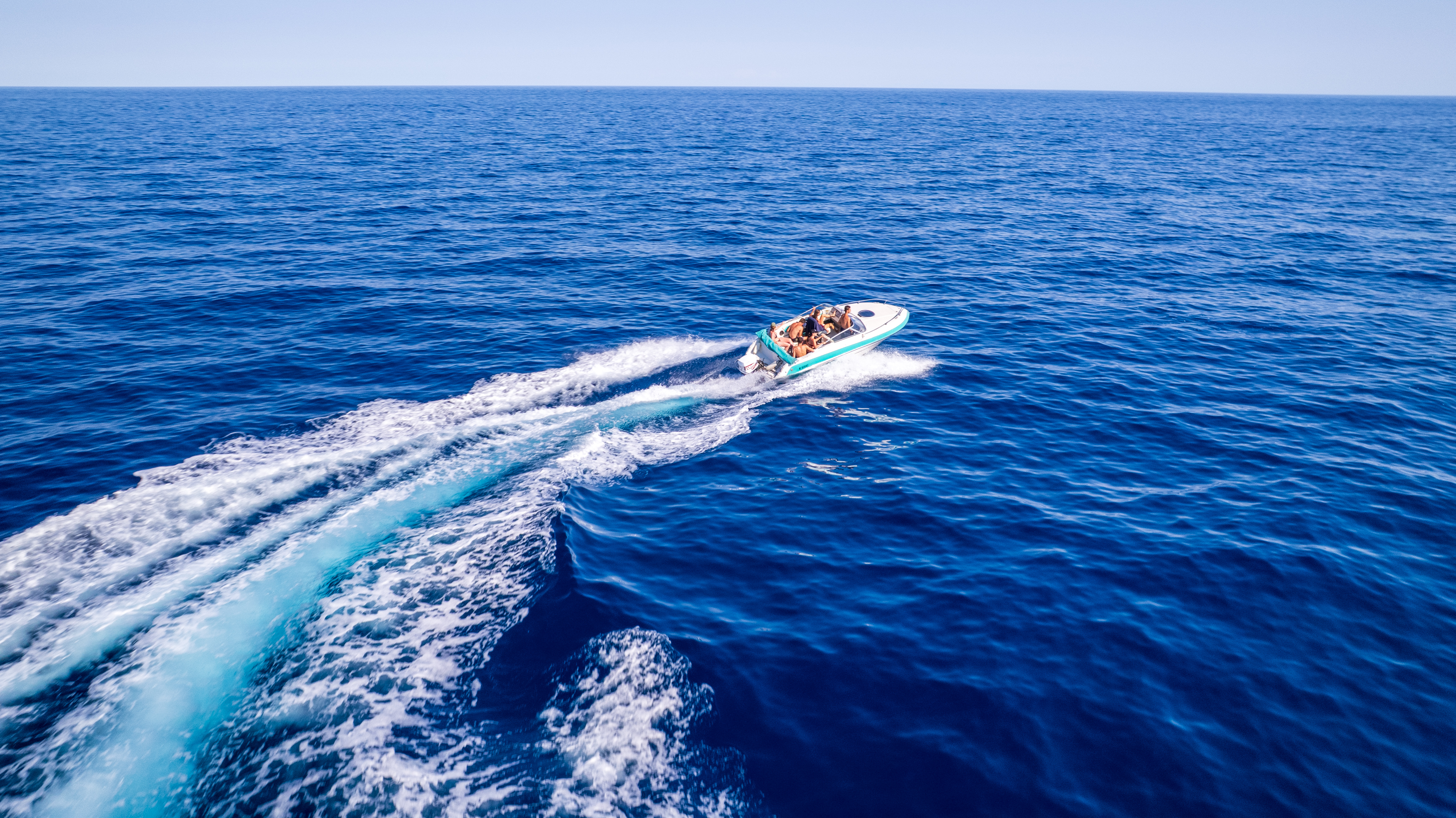 Bateau naviguant sur la mer bleue, vue aérienne oblique