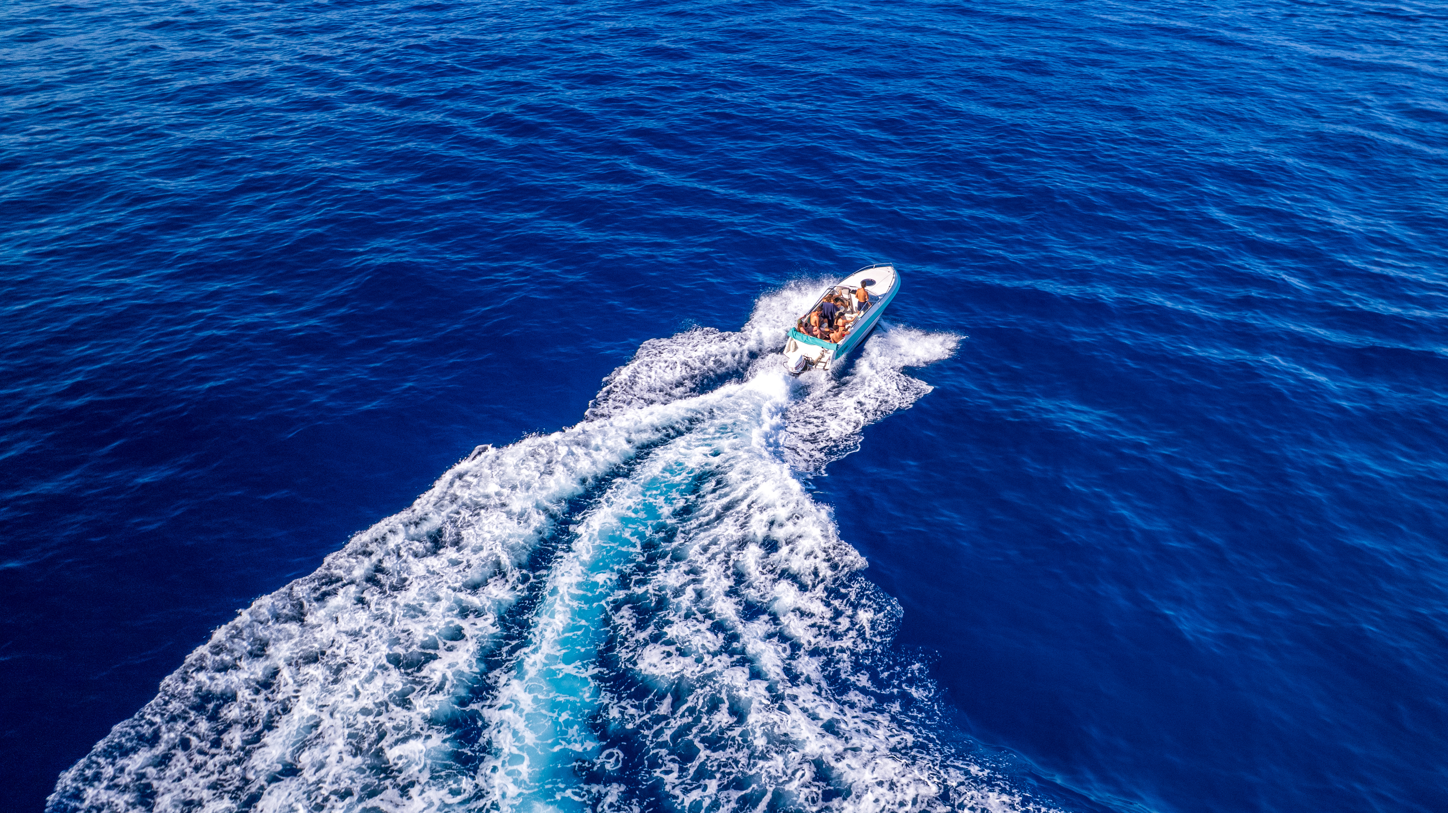 Bateau à moteur sur la mer bleue, photographié au drone